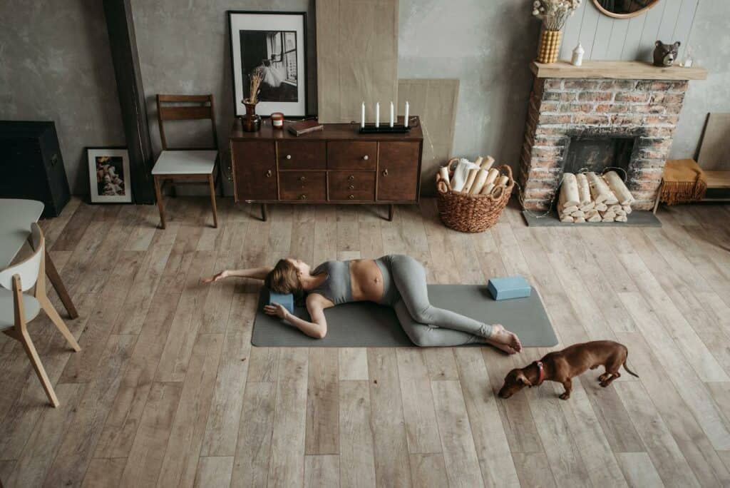 A Pregnant Woman in Gray Activewear Exercising at Home